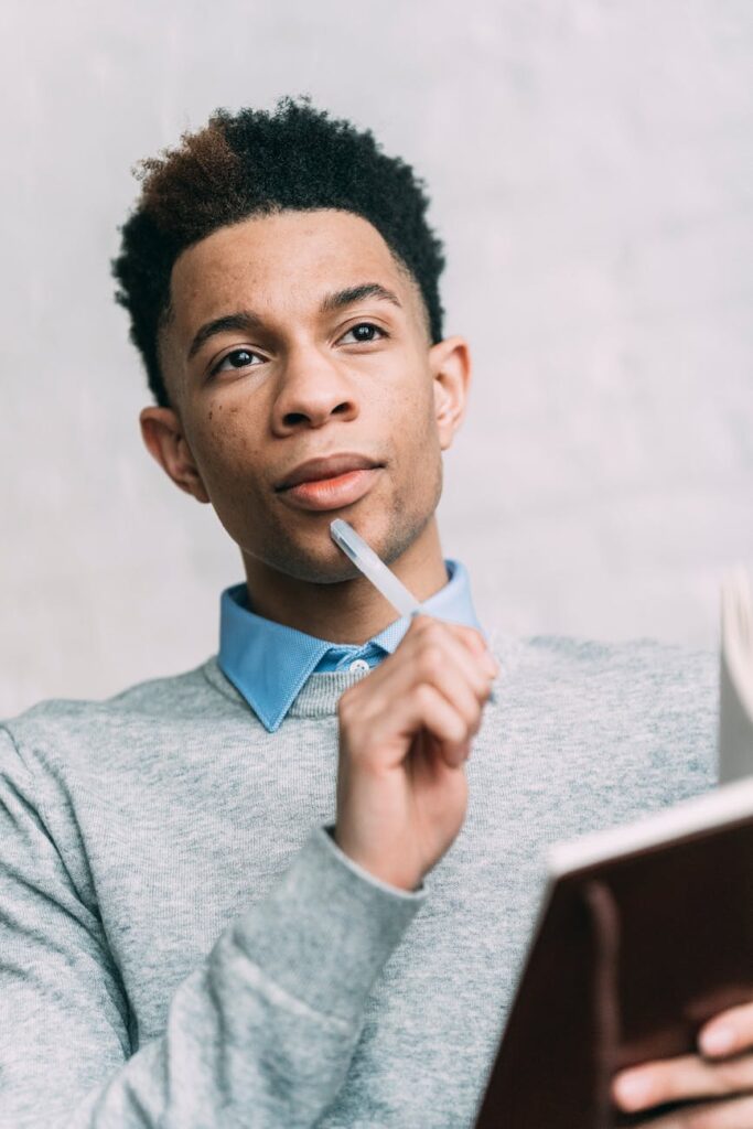 pensive black man making notes